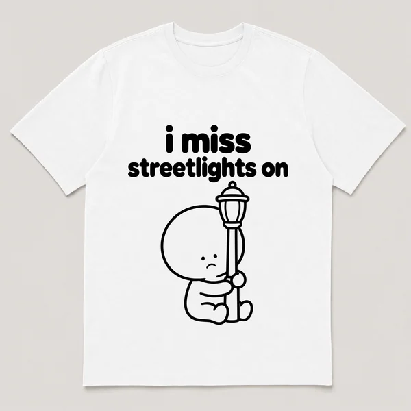 lonely boi tee: a small sad cartoon boy hugging a glowing streetlight at dusk, with the words i miss streetlights on above him